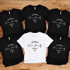 Personalised Hen Party T-shirts. Hen party Tees, Bride Tribe,Team Bride,Bridal Party Shirts,Bachelorette T-shirts. Wedding tops Hen night. Introducing our fabulous Hen Party T-shirt in Classic Black and white! Made with love from 100% cotton, this tee is the perfect addition to any bride and bridesmaid squad, ensuring you look and feel incredible during all your pre-wedding celebrations.  The bride's shirt is a classic white with a beautiful black print. The other hen party members' t-shirts are a stylish Black colour with a striking White print. These shirts are not only fashionable but also practical, as they can be worn by both men and women in your group so can give a relaxed fit feel. - Custom: Each t-shirt is carefully handmade to match your bridal party's unique style. We pay attent White Crew Neck Party Shirt, White Fitted T-shirt For Party, White Crew Neck T-shirt For Party, White Crew Neck Shirt For Party, Bachelorette Tops, Bridesmaid Squad, Wedding Tops, Bridal Party Shirts Bachelorette, Bachelorette T Shirts