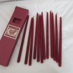 several red candles are lined up next to a box