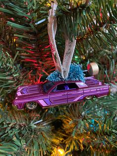 a purple car ornament hanging from a christmas tree