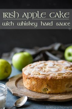 irish apple cake with whiskey hard sauce on a wooden plate next to some green apples