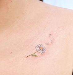 a woman's back with a flower tattoo on it