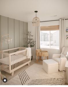 a baby's room with a crib, chair and ottoman