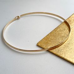 Estate/ vintage 14KT yellow gold round, flat wire collar necklace. This 14-karat yellow gold neck ring is made solid and a hard round shape. Length: 15.5” Width: 3.9mm Weight: 25.66 grams Hook clasp Choker length Clasp stamped Appears to be custom Flat on inside, close to the neck, half rounded outside Good condition Formal 14k Gold Choker Jewelry, Elegant 14k Gold Hoop Necklace, Gold Minimalist Choker For Formal Occasions, Adjustable Yellow Gold Choker Jewelry, Adjustable Yellow Gold Choker, Gold Plated Circular Jewelry For Formal Occasions, Adjustable Yellow Gold Plated Choker, Formal Circle-shaped Gold Plated Jewelry, Adjustable Yellow Gold-plated Choker