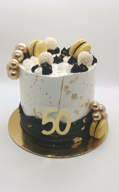 a 50th birthday cake decorated with gold and black decorations