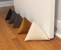 four different colored pillows sitting on the floor