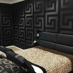 a bed room with a neatly made bed next to a wallpapered pattern on the wall