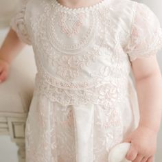 Handmade in the USA A gorgeous Baptism dress for your baby girl, our Elizabeth dress is handcrafted and expertly detailed. It is lined with rich silk Dupioni in an ivory color which enhances the gorgeous embroidered lace that falls over top. The soft pink and ivory embroidered Swiss Dot lace with cording is both comfortable and elegant, and will have everyone believing this is a handmade family dress passed down specially for your little one. Our vintage pink champagne Dupioni silk sash ties all Pink Lace Dress For First Communion, Fitted Embroidered Lace Baptism Dress, Elegant Pink Baptism Dress With Lace Bodice, Elegant Fitted Pink Baptism Dress, White Floral Embroidered Baptism Dress, Elegant Cream Lace First Communion Dress, White Floral Embroidery Baptism Dress, Lace Dress With Pearl Embroidery For Ceremony, Pink Ceremony Dress With Intricate Embroidery