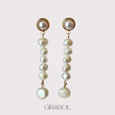 Step into elegance with our "Lorelai" Gold Plated Drop Earrings, adorned with natural pearls. These exquisite earrings are a testament to timeless beauty and sophisticated craftsmanship, perfect for adding a touch of luxury to any occasion. Crafted from high-quality gold plated metal, each earring features a delicate drop design that accentuates the natural luster and uniqueness of the pearls. The pearls, known for their organic shapes and iridescent hues, complement the warm gold finish beautifully, creating a harmonious blend of classic and contemporary styles. The "Lorelai" earrings are designed to capture attention with their graceful silhouette and subtle shimmer. Whether worn with an evening gown or paired with everyday attire, they effortlessly elevate your look with their understat White Pearl Button Earrings For Wedding, Graceful White Bridal Earrings With Pearl Charm, Graceful White Pearl Bridal Earrings, White Akoya Pearl Earrings For Wedding, White Akoya Pearl Wedding Earrings, Pearl Chain Earrings For Anniversary, Wedding Akoya Pearl Earrings With Pearl Charm, White Pearl Button Wedding Jewelry, Pearl White Akoya Pearl Drop Bridal Earrings