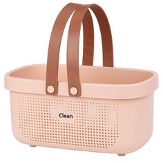 a pink plastic basket with brown handles and leather straps on the handle is shown in front of a white background