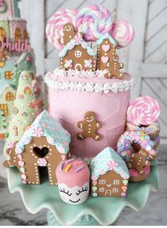 there is a pink cake decorated with gingerbreads and other decorations on the table