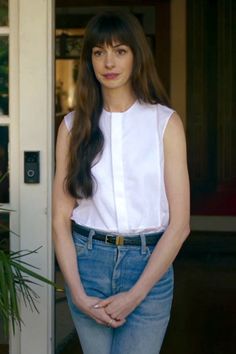 a woman standing in front of a door with her hands on her hips and looking at the camera