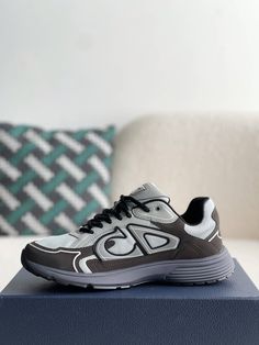 Embrace a sleek and sporty aesthetic with these Dior B30-inspired sneakers in a sophisticated grey and anthracite colorway. Crafted with breathable mesh and technical fabric, these shoes are perfect for those who value both style and performance. The lightweight construction and sculpted rubber sole ensure all-day comfort and support, while the signature "CD30" logo adds a touch of Dior's iconic style. Whether you're hitting the gym or the streets, these sneakers will elevate your look with a to Gray Running Shoes With Abzorb Midsole, Modern Gray Sneakers With Reflective Details, Gray Dynamic Mesh Sneakers, Casual Running Sneakers With Reflective Logo, Dynamic Gray Mesh Sneakers, Modern Gray Mesh Sneakers, Dynamic Gray Sneakers For Jogging, Modern Gray Sneakers For Light Sports, Modern Gray Running Shoes With Branded Insole