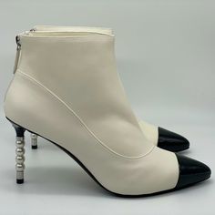 These Ivory White Lambskin Leather Booties Feature A Pointed Black Patent Calfskin Cap Toe. Faux Pearl Silvertone Metal Cc Embossed Detail On The 3.5" Patent Leather Heel. Back Zip. Padded Leather Insole And Leather Sole. Made In Italy. Designer Color: Black. Size: 40.5 Eu (Insole Measures 10.5", Heel: 3.5"). Typically Chanel Shoes Run Small. Brand New With The Box. Luxury White Heeled Boots, Elegant White Heeled Boots With Round Toe, Luxury White Heeled Boots For Formal Occasions, White Boots For Evening In Winter, White Winter Boots For Evening, White Winter Evening Boots, Elegant White Heeled Boots For Formal Occasions, Elegant White Evening Boots, Elegant Cream Heeled Boots For Winter