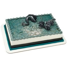 a cake decorated with two dragon figurines on top of a green and white plate