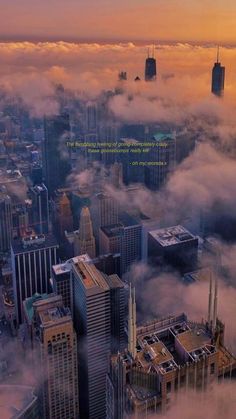 an aerial view of skyscrapers and clouds in the city