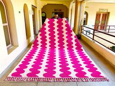 a large pink and white rug on the ground