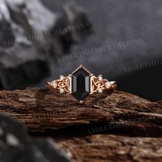 a black stone ring sitting on top of a piece of wood