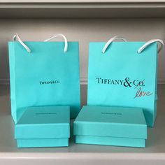 two tiffany & co bags sitting on top of each other