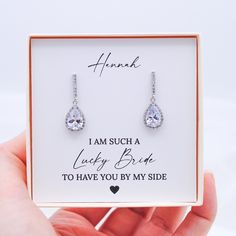 a pair of earrings in a gift box with thank written on the front and back