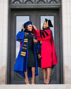 two women in graduation gowns standing on steps