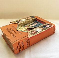 two books sitting on top of each other with pictures in them, one is open and the other is closed