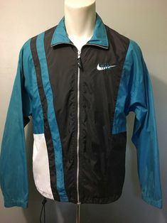 Preowned vintage men’s, 1990s, unique and sporty, Nike brand, grey tag swoosh logo, black, teal-blue and white color-block nylon, full zip-up, jogger, jumper, lightweight windbreaker coat. Classic retro old-school, tennis, track and field, jogging, running warmup jacket shell featuring mesh back vents, 2 zip pockets, drawstring waist, gray YKK zipper and embroidered script chest design. Light wear, stains on sleeves and white area, small pinhole right cuff area, otherwise, good condition, see pi Running Warmup, Chest Design, Coat Classic, 90s Nike, Nike Brand, Design Light, Swoosh Logo, Logo Black, Ykk Zipper