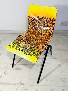 a yellow and black chair sitting on top of a hard wood floor