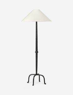 a floor lamp with a white shade on it's base and a black stand