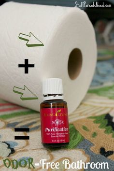 a roll of toilet paper sitting on top of a table next to a bottle of essential oils