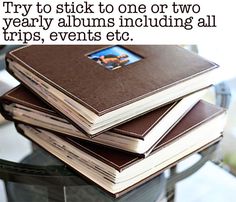 a stack of books sitting next to each other on top of a table with the caption, try to stick to one or two yearly albums including all trips, events etc