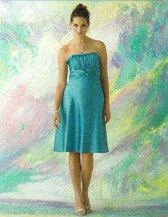 a woman standing in front of a painting wearing a blue dress and high heeled sandals