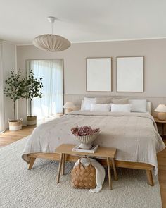 a large white bed sitting in a bedroom on top of a hard wood floor