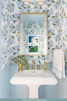 a white sink sitting under a bathroom mirror next to a wall mounted faucet