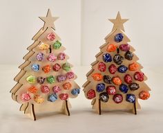 two wooden christmas trees with candy candies in them