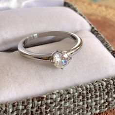 a diamond ring sitting on top of a cushion