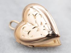 "This beautiful yellow-gold etched heart locket is sure to become a treasured keepsake. Crafted from yellow gold, the intricate detailing creates a lasting impression. Its petite heart shape makes it a perfect gift for a loved one. This pendant does not come with the chain shown. Please feel free to contact us, we will help you find the perfect chain for your style and budget! Metal: 14K Yellow Gold Measurements: 15 x 22 mm, with bail Marks: \"14KT BAB\" Stamped To view a video of this piece check out the link below: https://vimeo.com/834876038 SKU #: A27675 Each piece has been identified and graded by a Graduate Gemologist who has been certified by the Gemological Institute of America (GIA). We have six brick-and-mortar storefronts in Maine, Massachusetts, and New Hampshire and have been Locket Gold, Gold Heart Locket, Gold Locket, Heart Locket, Valentines Gift, Locket Necklace, Gold Heart, Heart Of Gold, Gold Style