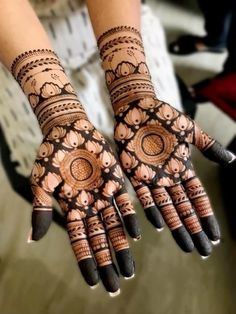 two hands with henna designs on them