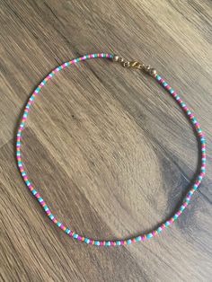 a multicolored beaded necklace on a wooden surface