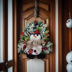 a snowman wreath is hanging on the front door