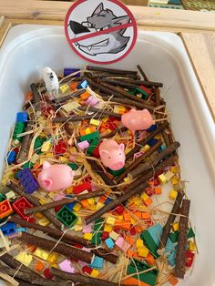 a white tray filled with lots of different colored legos and animals next to a sign that says do not feed the pigs