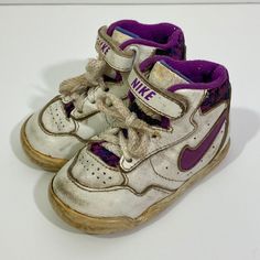 Little kid's vintage 1991 Nike high top sneakers. The shoes have a fabulous 90's color scheme with purple swoosh and purple patterned tongue and back. The shoes have short white laces and a hook and loop strap. They are super rare! I can't seem to find another pair on the internet.  The sneakers are in play condition. There is quite a bit of scuffing, cracking and chipping as pictured.  Size 3.5 5 1/4 inches long Vintage Low-top Basketball Shoes, Vintage White Basketball Shoes, Vintage White High-top Basketball Shoes, Vintage Pink Sneakers With Round Toe, Vintage Pink High-top Sneakers, Vintage White Skate Shoes With Round Toe, Nike 90s Shoes, 90s Nike Shoes, Nike High Top Sneakers