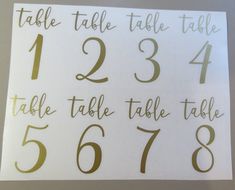 the table numbers are written in gold on white paper