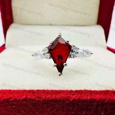 Vintage Kite Shaped Red Garnet Engagement Ring, Promise Ring, Wedding Ring, Bridal Ring, January Birthstone Ring, Anniversary Gift For Women All type of jewelry like Pendant, Nacklace, Rings, earrings and all type of marvellous item available  It is made by hand Metal & Metal Purity:- 925 Sterling Silver With nickel free Rhodium Main stone:- Garnet  Side Stone :- Cubic Zirconia  Stone Size :- 7x11MM Stone Shape :- Kite  Band Color :- I offer more than one  Ring Size :- All Size Available Made In:- Jaipur, Rajasthan Contact us if your ring size is not available in the listing.  To change the metal to a solid gold (white/rose) or platinum is also available, please ask for questions if you want. Makes a Wonderful Gift 🎁 for your Girlfriend, Wife, Mom or Simply an Excellent Addition to Your J January Birthstone Rings, Garnet Engagement Ring, January Birthstone, Jaipur Rajasthan, Gifts For Your Girlfriend, Ring Promise, One Ring, Bridal Ring, Red Garnet