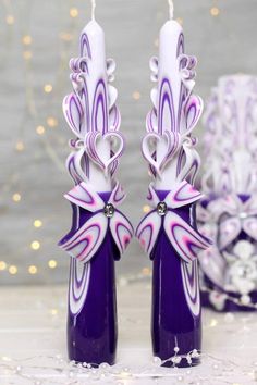 two purple vases with white and pink designs on them sitting next to each other