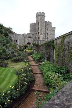 an old castle with many plants and flowers around it