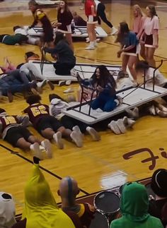 several people sitting on the floor with tennis rackets in their hands and one person laying on the floor