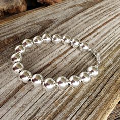 "Beautiful! Classy but simple everyday wear. All shiny round ball 10mm sterling silver bead bracelet. 10mm (LARGE) smooth shiny ball sterling silver beads. 🚩 IMPORTANT IMPORTANT 🚩 10mm are LARGE beads which affects the INSIDE circumference and takes up more room than smaller beads. Please allow a extra room when choosing length. MEASURE WRIST: wrap string around wrist (not tight) and measure end to end. Add about 3/4\" - 1\", depending on your \"comfort\" fit length - loose fit or snug fit. Le Adjustable Beaded Bracelet With Ball Chain For Gifts, Adjustable Ball Chain Beaded Bracelets As Gifts, Adjustable Ball Chain Beaded Bracelet For Gift, Classic Silver Beaded Bracelets As Gift, Classic Adjustable Sterling Silver Bracelet With Spacer Beads, Classic Silver Bracelets With 8mm Beads, Classic Sterling Silver Bracelet With Beads, Classic Silver Beaded Bracelets With 8mm Beads, Classic Adjustable Sterling Silver Bracelet With Polished Beads