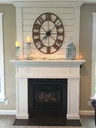 a living room with a fireplace and clock on the wall above it's mantle