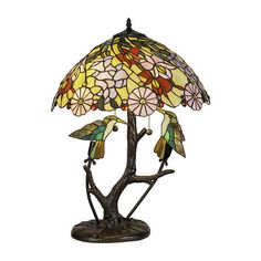 a lamp that is sitting on top of a tree branch with flowers in the middle