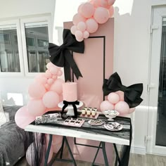 a table topped with pink and black balloons